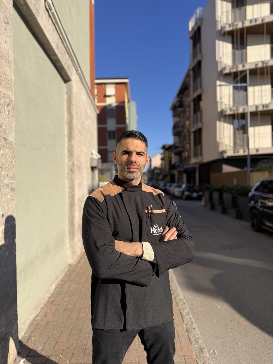 Lo chef Abbas Habibi davanti al ristorante Phoenicia, in divisa da cucina.