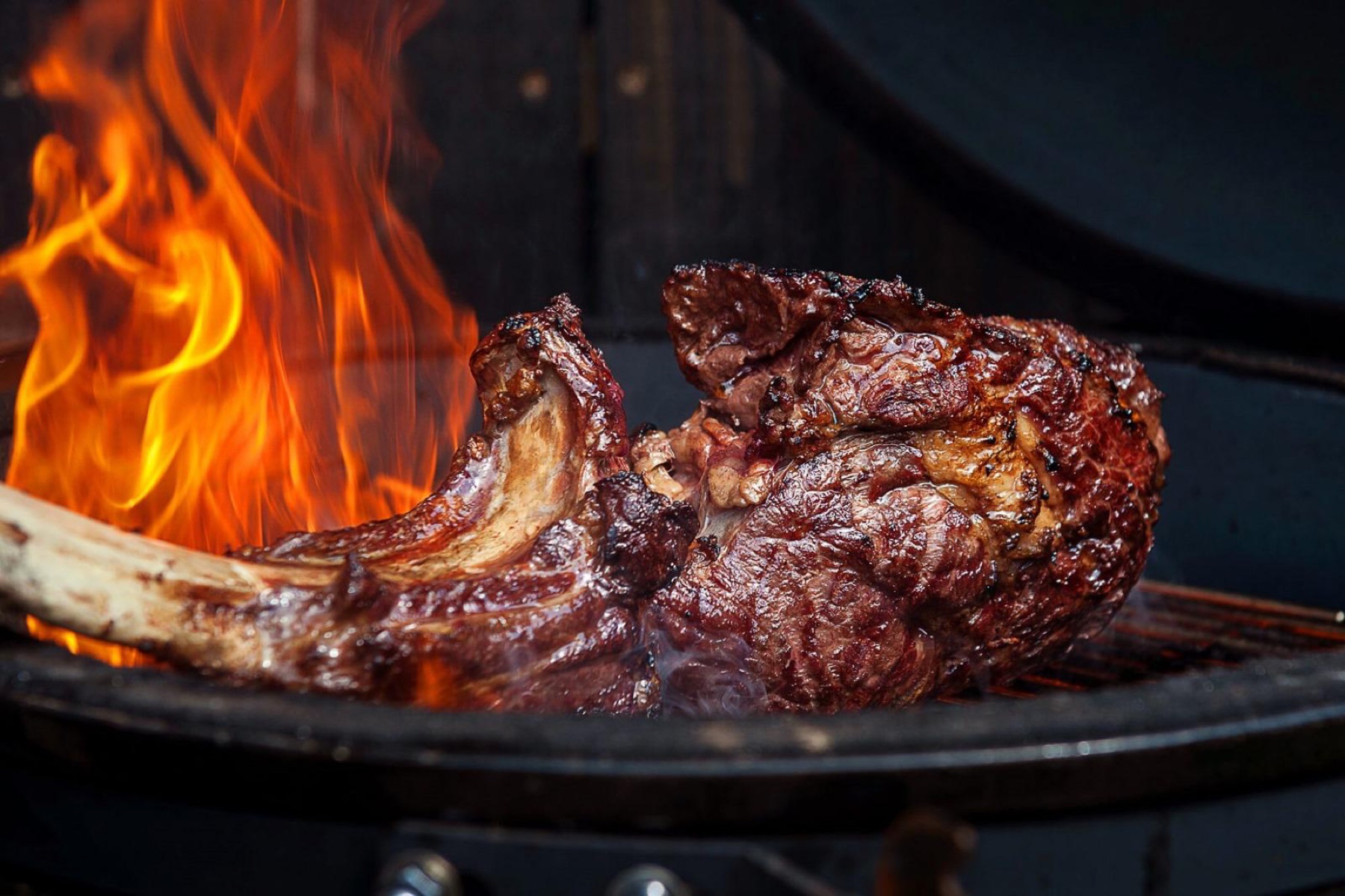 Taglio di carne alla brace, tra le fiamme vive del grill.