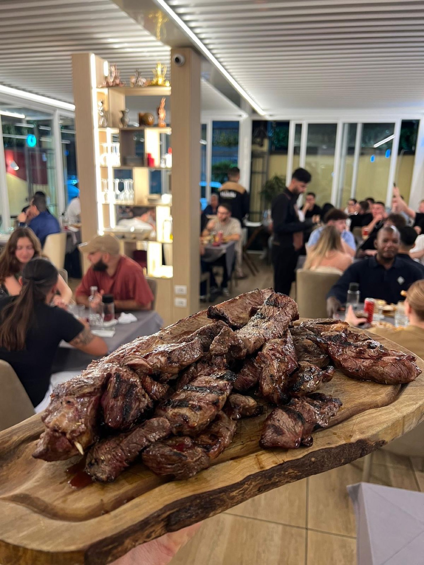 Ospiti a cena nella sala di Phoenicia, tra le luci calde della sera.