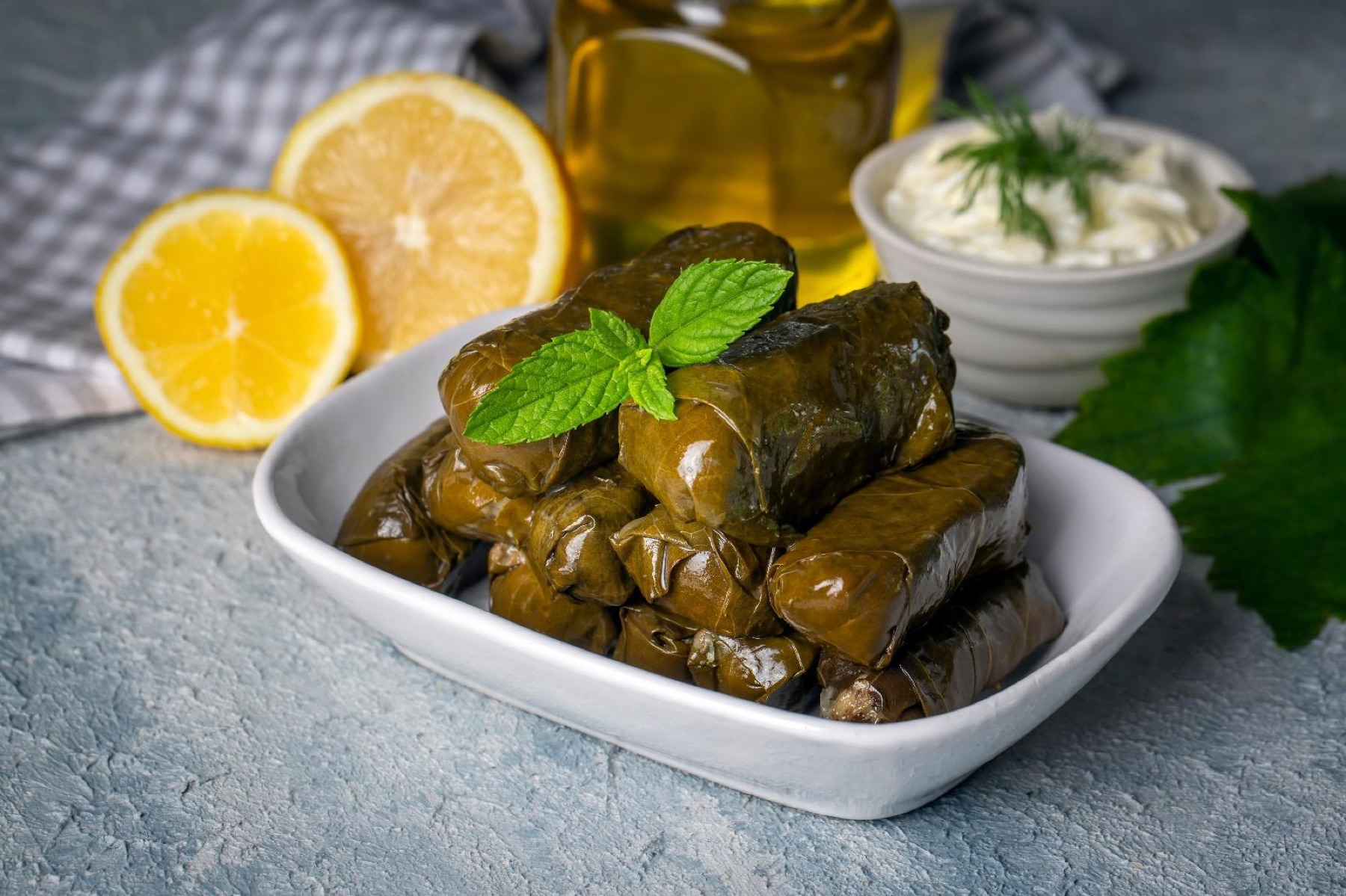 Foglie di vite ripiene servite con olio e limone, parte del mezé condiviso.