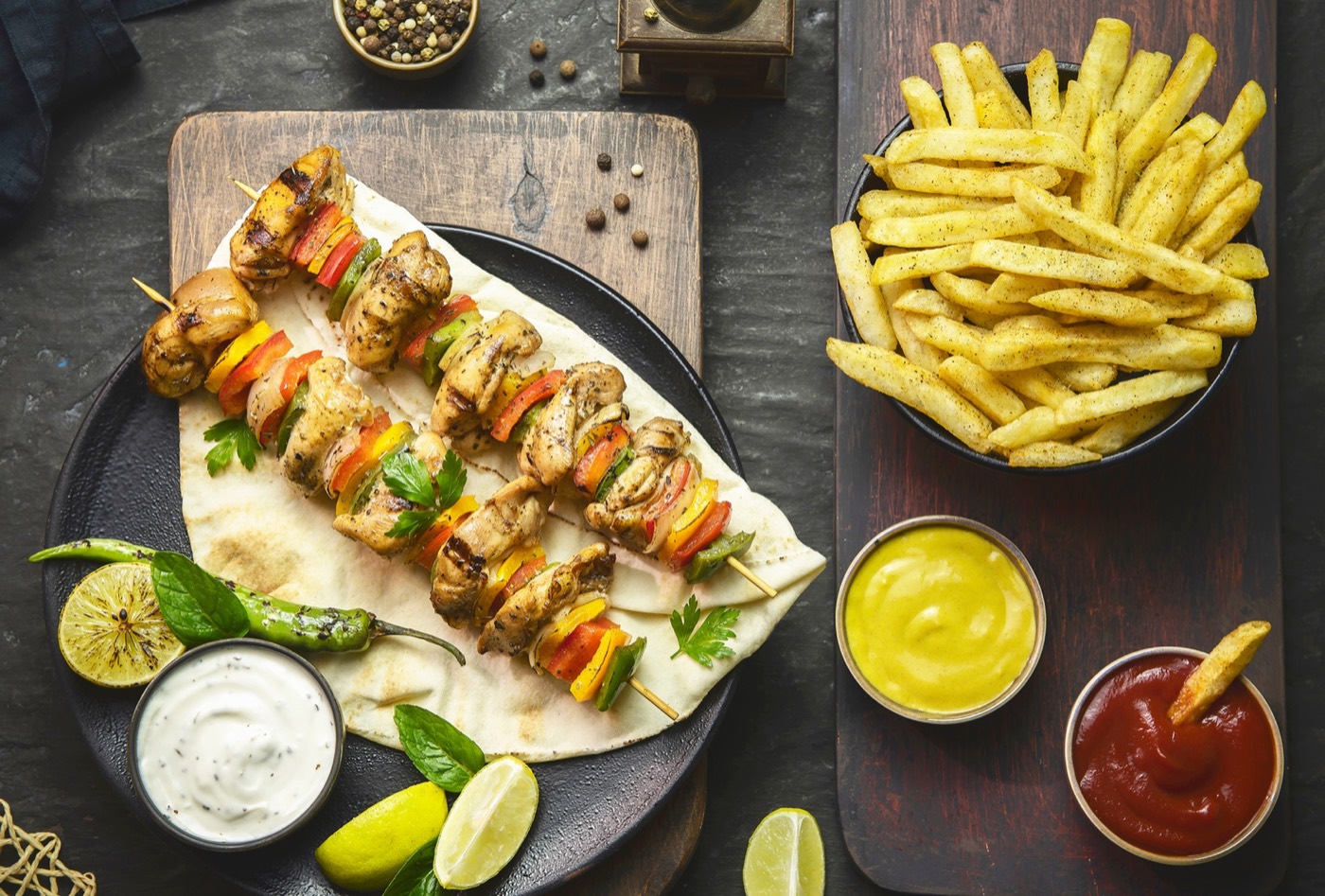 Spiedini shish taouk Habibi con patatine e salse.